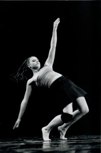 Photographie en noir et blanc de Sophie Caminade en mouvement de danse contemporaine sur scène