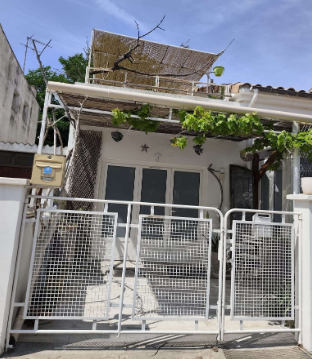 Façade extérieure avec portail blanc, terrasse abritée sous pergola et toit-terrasse à la Maison Oyat's Mer au Grau-du-Roi
